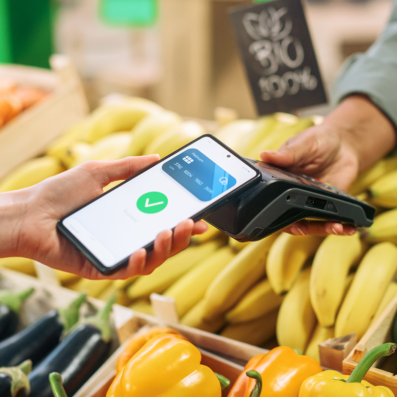 Digital banking concept shopper using cellphone with contactless payment technology to pay for